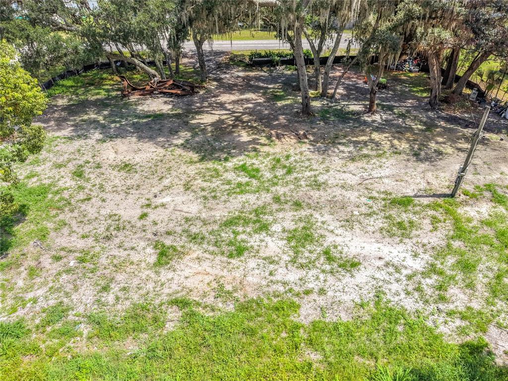 An elevated view of a vacant, sandy lot with scattered trees and some debris — 15832 BERMUDA STREET, ORLANDO, FL