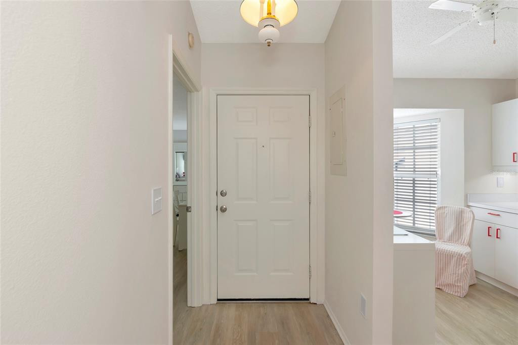 An entryway features a white front door, light wood-look flooring, and a ceiling light fixture — 1216 SPOONBILL LANDINGS CIRCLE, BRADENTON, FL