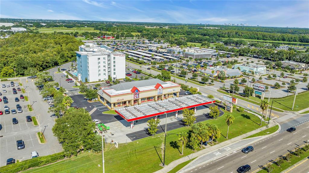 An aerial view shows a gas station, a hotel, and a large parking lot — 5600 BUTLER NATIONAL DRIVE, ORLANDO, FL