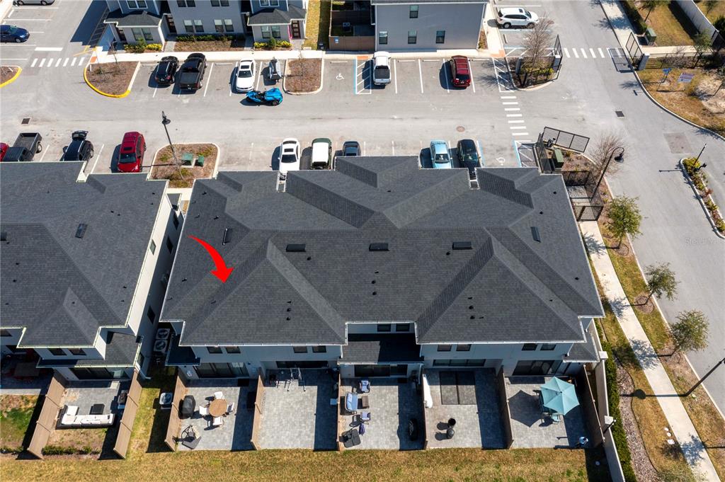 An aerial view shows the shingled roof of a multi-unit townhouse with private back patios — 4708 TERRA ESMERALDA DRIVE, KISSIMMEE, FL