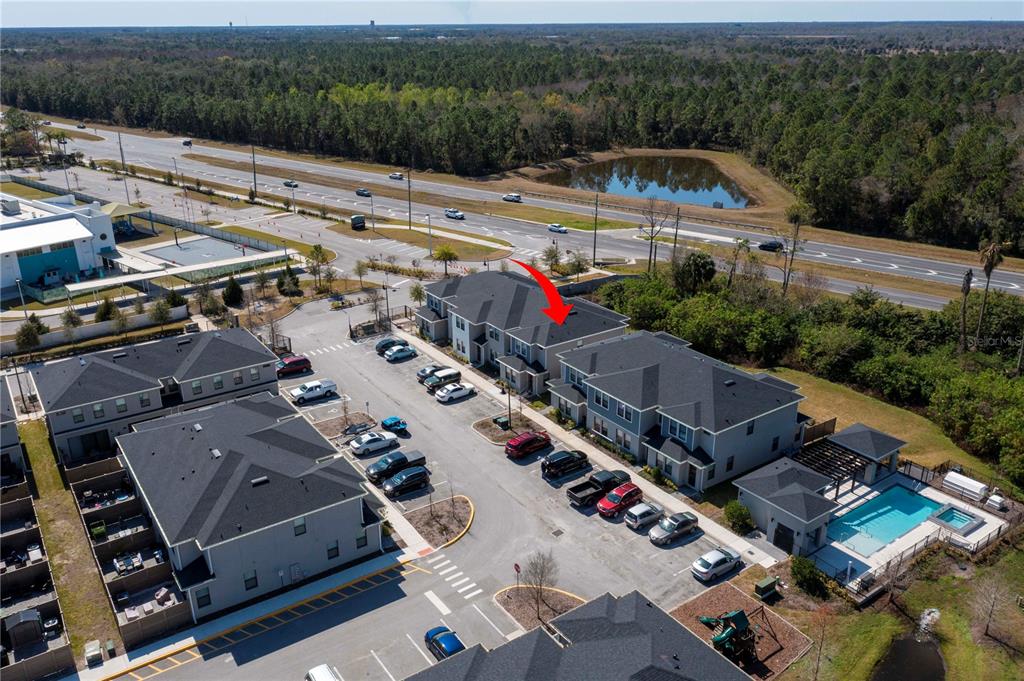 An aerial view shows a multi-unit residential building with a swimming pool and parking lot — 4708 TERRA ESMERALDA DRIVE, KISSIMMEE, FL