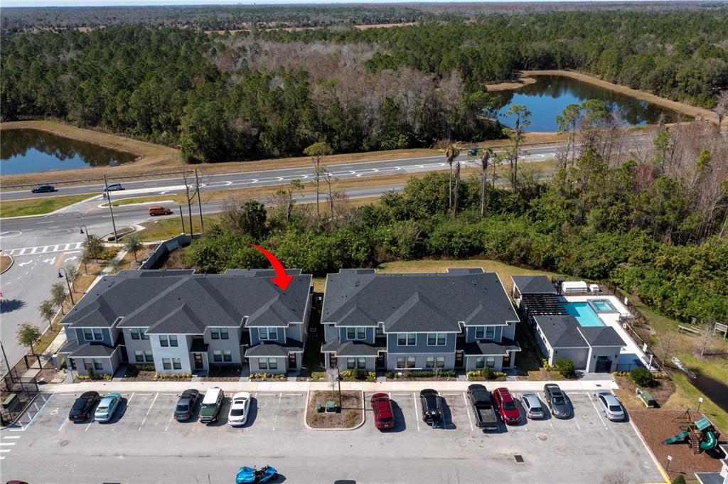 An aerial view shows two multi-unit residential buildings with a parking lot and swimming pool — 4708 TERRA ESMERALDA DRIVE, KISSIMMEE, FL