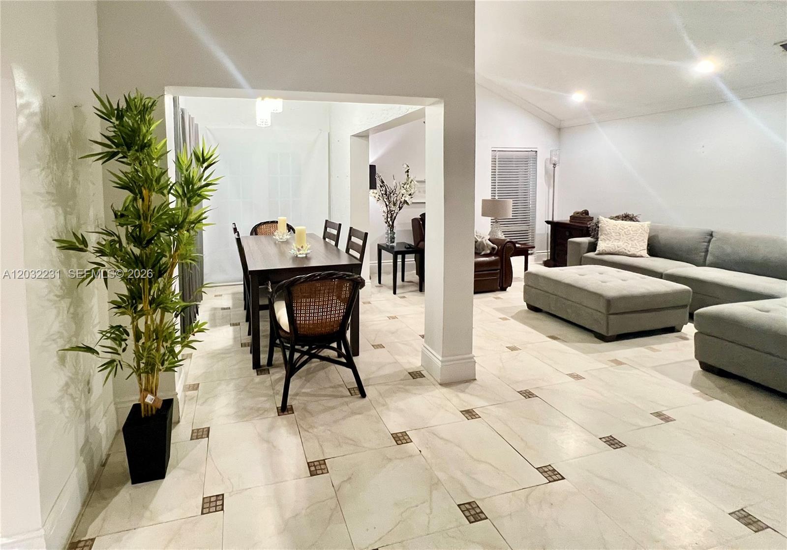 An open-concept living and dining area features light tile flooring with dark decorative insets — 11769 SW 92nd Ln, Miami FL 33186, MIAMI, FL