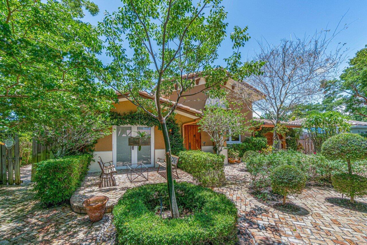 A brick patio sits in front of a house with a tree and manicured hedges — 870 NW 7th Street, Boca Raton FL 33486, BOCA RATON, FL