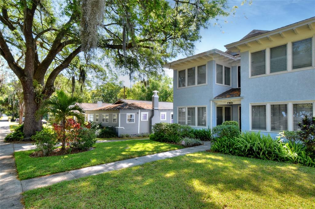 A two-story light blue house with a front lawn and a large oak tree — 211 E PARK STREET, LAKELAND, FL