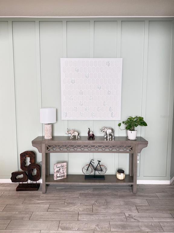 A console table with decor sits against a light green board and batten accent wall — 1873 SPRING SHOWER CIRCLE, KISSIMMEE, FL