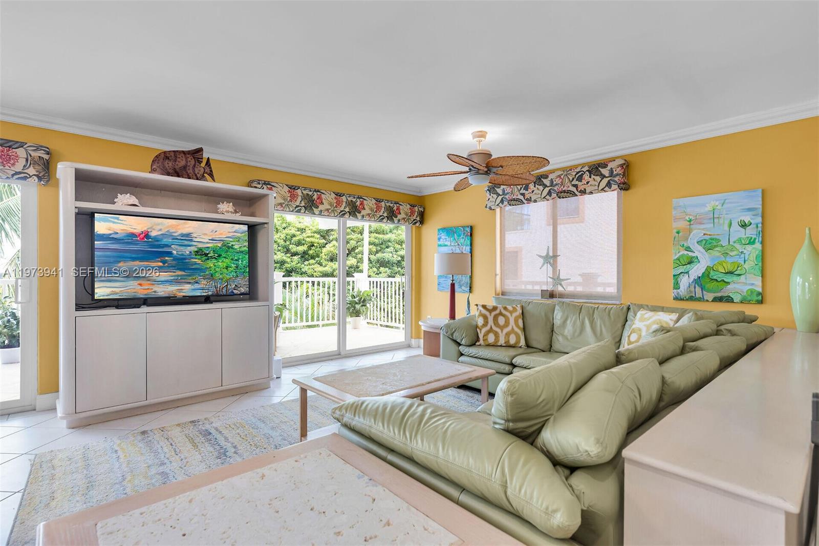 A living room features yellow walls, a light green sectional sofa, and a television console — 1218 Mockingbird Rd, Key Largo FL 33037, KEY LARGO, FL