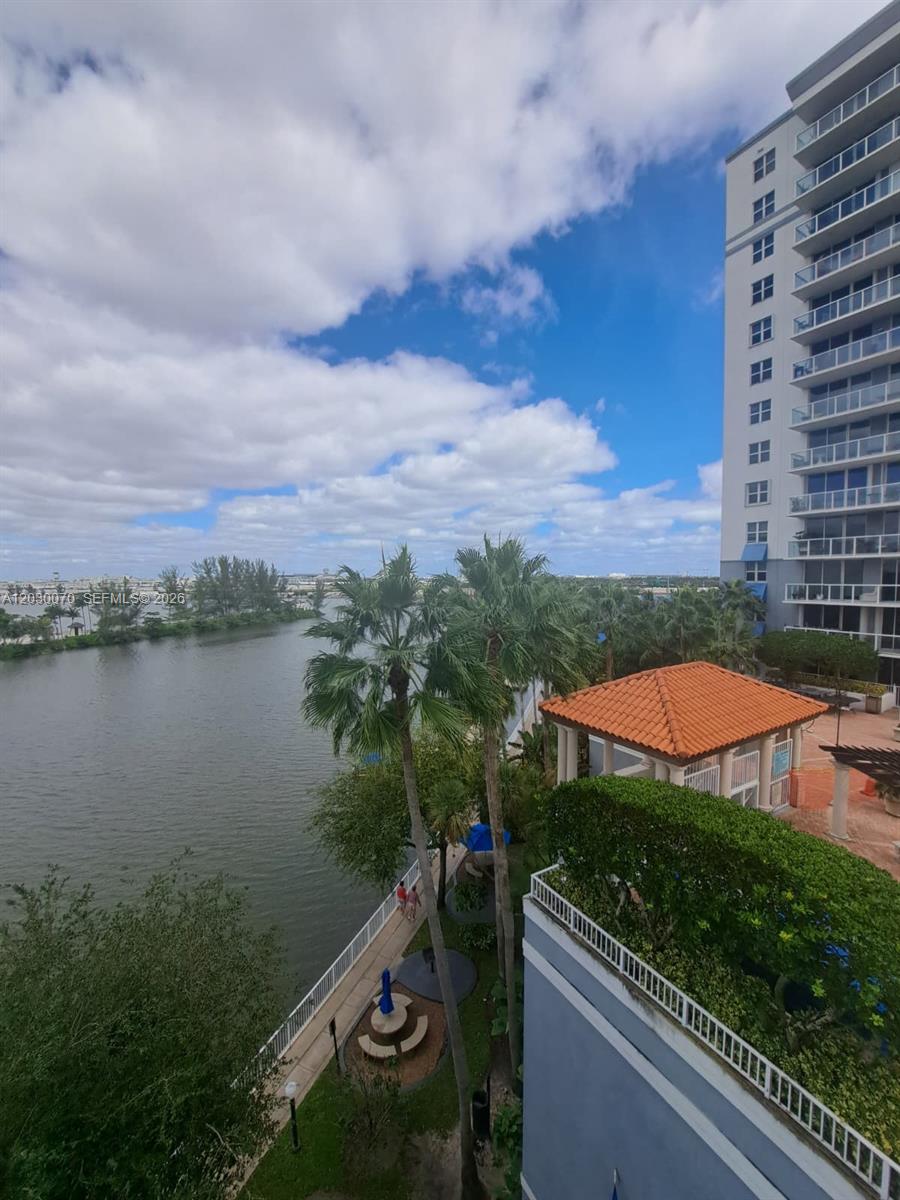An elevated view of a canal, palm trees, a gazebo, and a high-rise apartment building — 5085 NW 7th St # 602, Miami FL 33126, MIAMI, FL