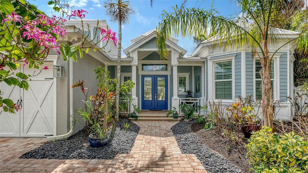 A blue-trimmed house features a brick walkway leading to a double-door entrance — 1794 CUNLIFF LANE, SARASOTA, FL