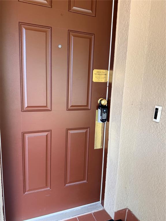 A brown front door features a keypad lock, a peephole, and a no-soliciting sign — 218 RONALDALE AVENUE, HAINES CITY, FL