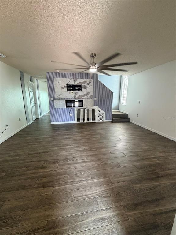 A living area features wood-look tile flooring, a ceiling fan, and a built-in fireplace wall — 218 RONALDALE AVENUE, HAINES CITY, FL