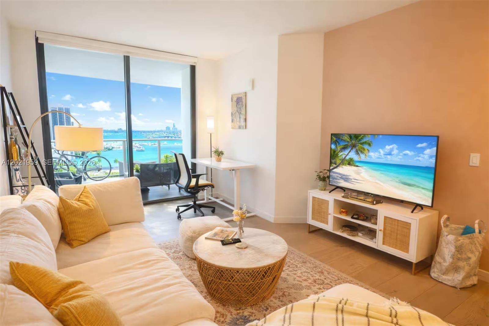 A living room features a white sofa, a round coffee table, and a balcony view — 1600 NE 1st Ave # 1605, Miami FL 33132, MIAMI, FL