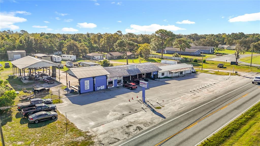 An aerial view shows a commercial auto repair shop with a large parking lot — 16924 SHADY HILLS ROAD, SPRING HILL, FL