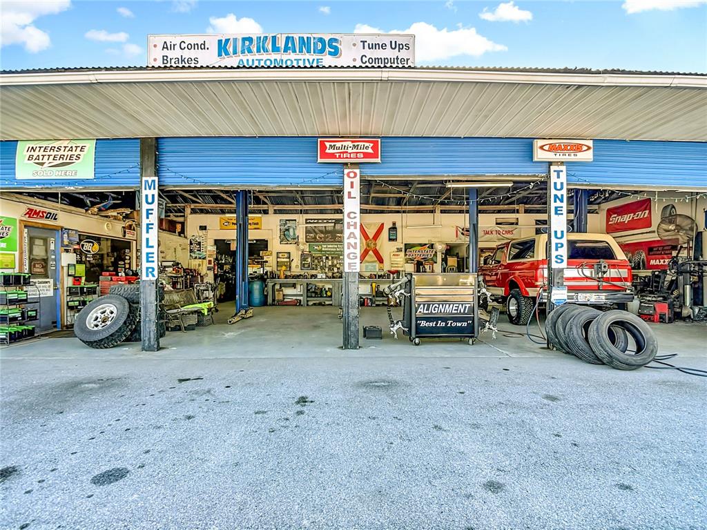 The exterior of an automotive repair shop features multiple service bays and signage — 16924 SHADY HILLS ROAD, SPRING HILL, FL