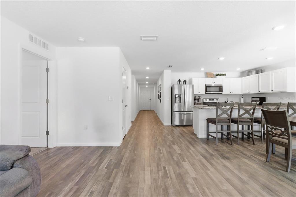 A view of a kitchen with white cabinets and an island overlooking a hallway — 8830 N SPARTAN DRIVE, CITRUS SPRINGS, FL