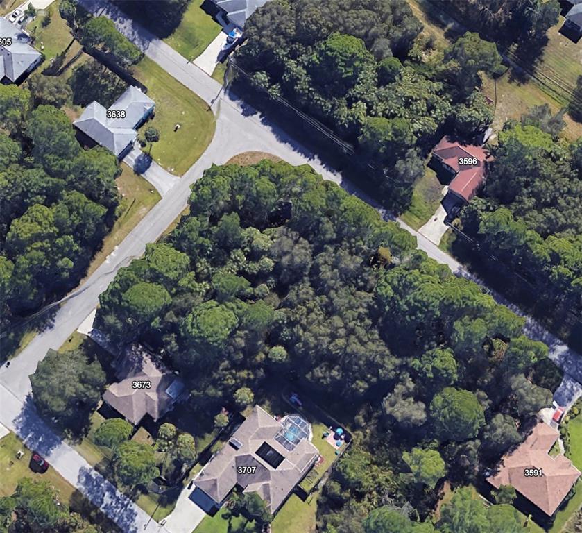 This aerial view shows several houses surrounded by dense trees and paved residential streets — Lot 13 GIBLIN DRIVE, NORTH PORT, FL