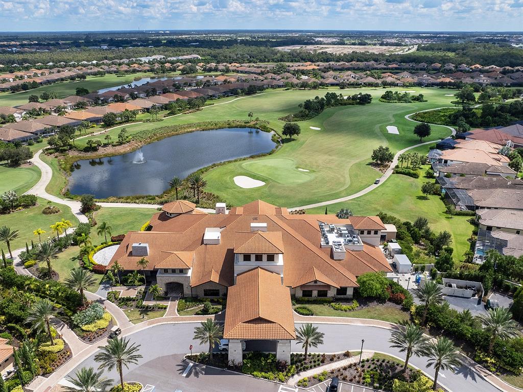 An aerial view shows a large clubhouse with a tiled roof overlooking a golf course — 5137 NAPOLI RUN, BRADENTON, FL