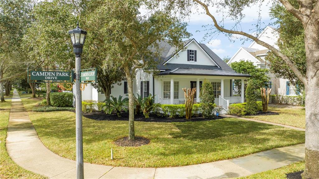 A white house with a covered front porch sits on a corner lot — 11339 CAMDEN PARK DRIVE, WINDERMERE, FL