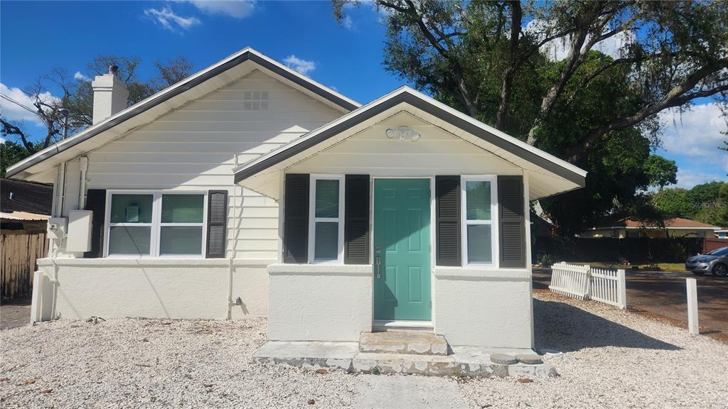 A single-story house with white siding, a teal front door, and a gravel front yard — 2117 5TH STREET UNIT Front House, SARASOTA, FL