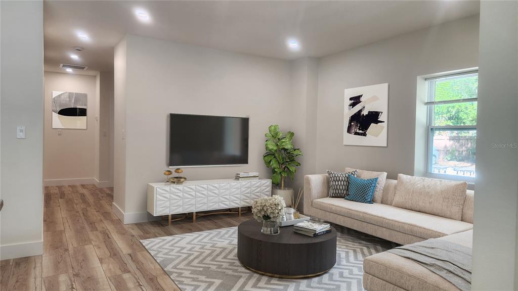 A living room features a sectional sofa, a round coffee table, and a wall-mounted television — 2117 5TH STREET UNIT Front House, SARASOTA, FL