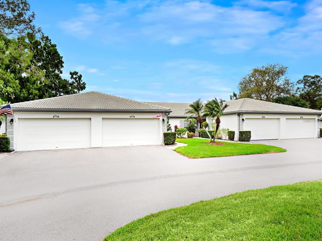 A low-slung house with a three-car garage and a large paved driveway — 3130 RINGWOOD MEADOW UNIT 44, SARASOTA, FL