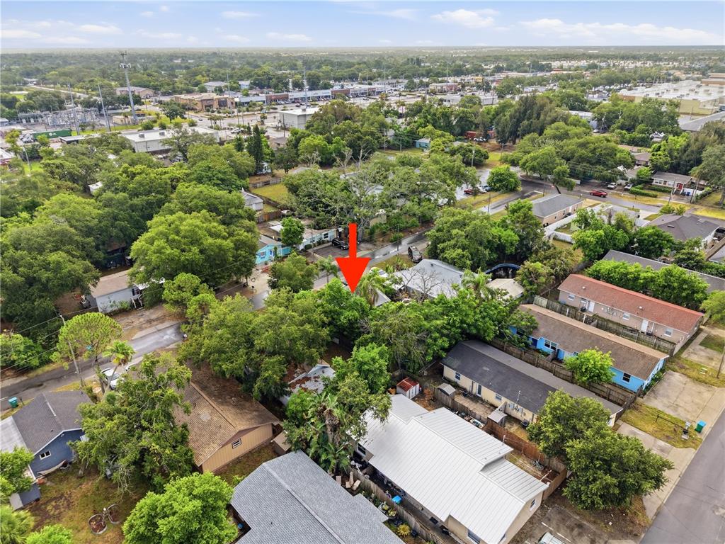 An aerial view shows a residential neighborhood with houses surrounded by many mature trees — 1734 CRAWFORD AVENUE, CLEARWATER, FL