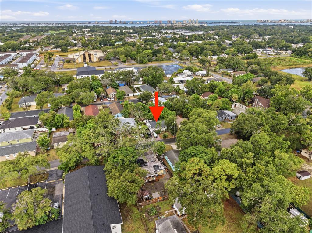 An aerial view shows a residential neighborhood with a red arrow pointing to a house — 1734 CRAWFORD AVENUE, CLEARWATER, FL