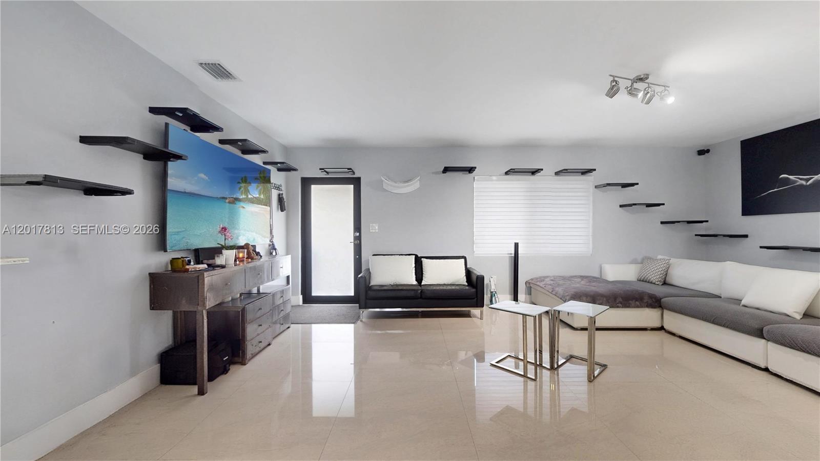 A living room features light tile floors, a large television, and floating wall shelves — 12535 SW 31st Ter, Miami FL 33175, MIAMI, FL