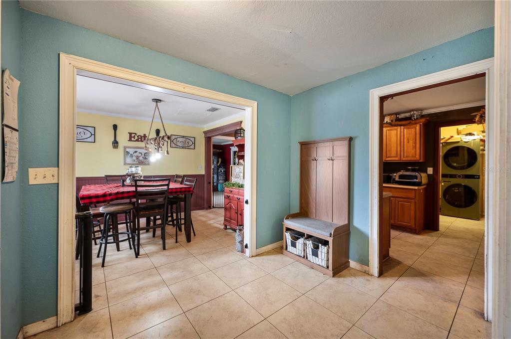 A tiled entryway features a wooden hall tree and doorways leading to a dining room — 4911 WHITEOAK DRIVE E, LAKELAND, FL