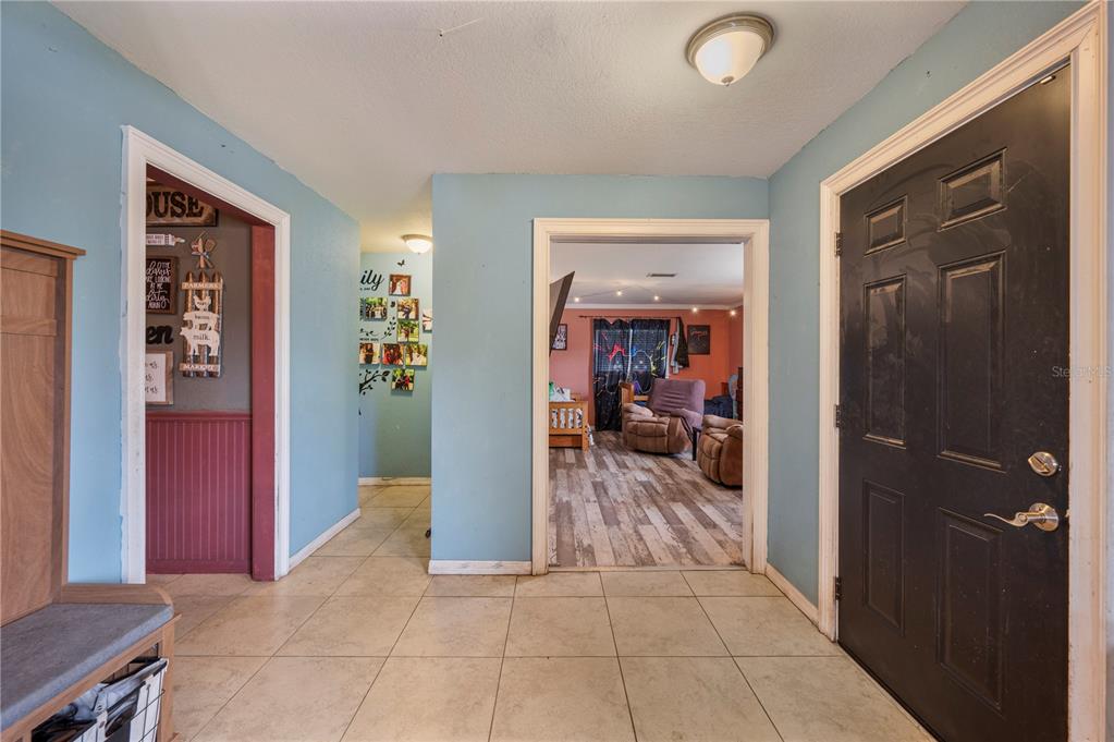 An entryway with tile flooring leads to a living room and a hallway — 4911 WHITEOAK DRIVE E, LAKELAND, FL