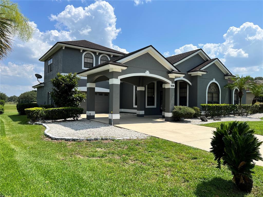 A gray two-story house with a covered entryway and a concrete driveway — 508 LANARKSHIRE PLACE, APOPKA, FL