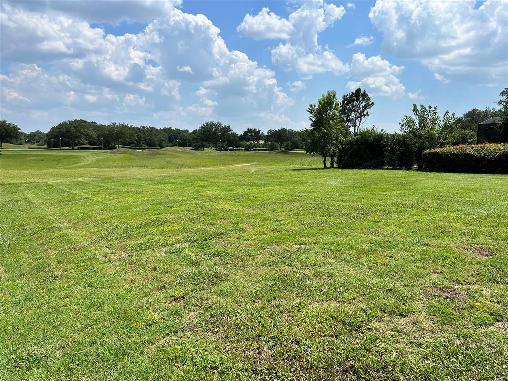 A grassy lot overlooks a golf course under a bright, cloudy sky — 508 LANARKSHIRE PLACE, APOPKA, FL