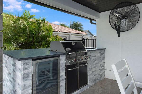 An outdoor kitchen features a stainless steel grill, a beverage cooler, and stone veneer siding — 839 Enfield Street, Boca Raton FL 33487, BOCA RATON, FL
