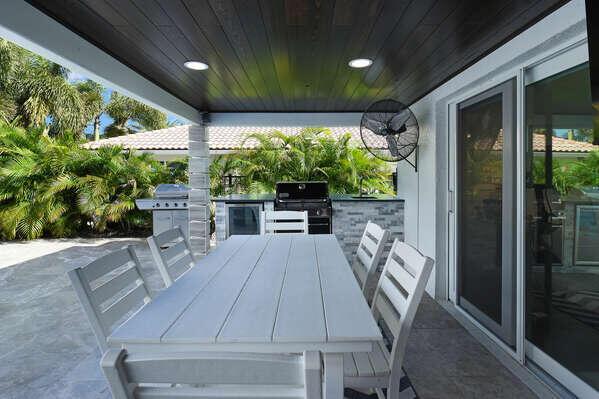 A covered outdoor patio features a white dining set, a built-in grill, and a ceiling fan — 839 Enfield Street, Boca Raton FL 33487, BOCA RATON, FL