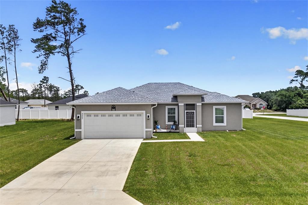 A single-story gray house with a two-car garage and a concrete driveway — 3557 SW 128TH PLACE, OCALA, FL