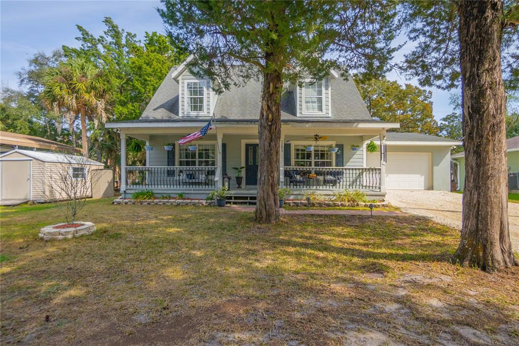 A two-story house with a front porch, dormer windows, and a gravel driveway — 2283 S TODD POINT, HOMOSASSA, FL