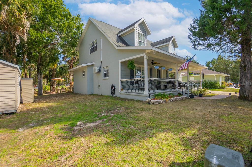 A two-story house with a covered front porch, dormer windows, and a side yard — 2283 S TODD POINT, HOMOSASSA, FL