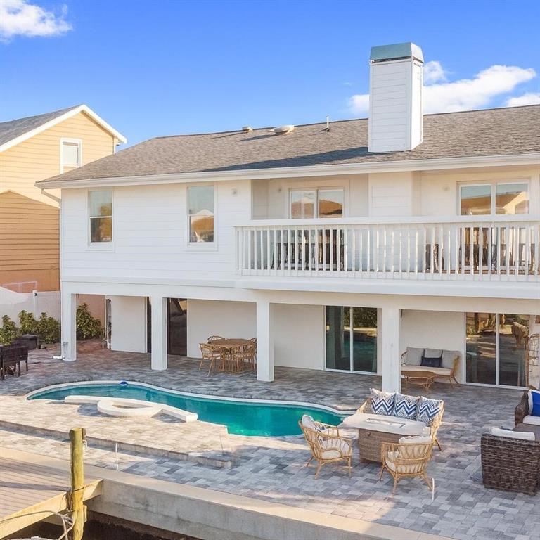 A white two-story house features a backyard pool, patio furniture, and a wooden dock — 328 6TH AVENUE, INDIAN ROCKS BEACH, FL