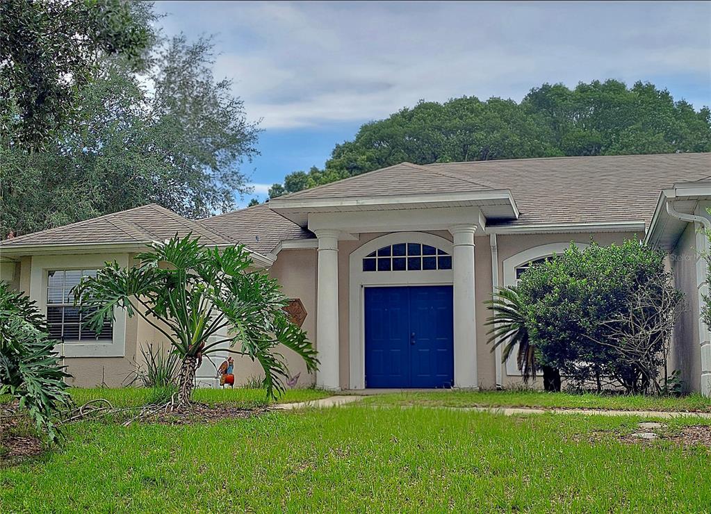 A single-story house with a blue double front door and two white columns — 13518 PALO COURT, CLERMONT, FL