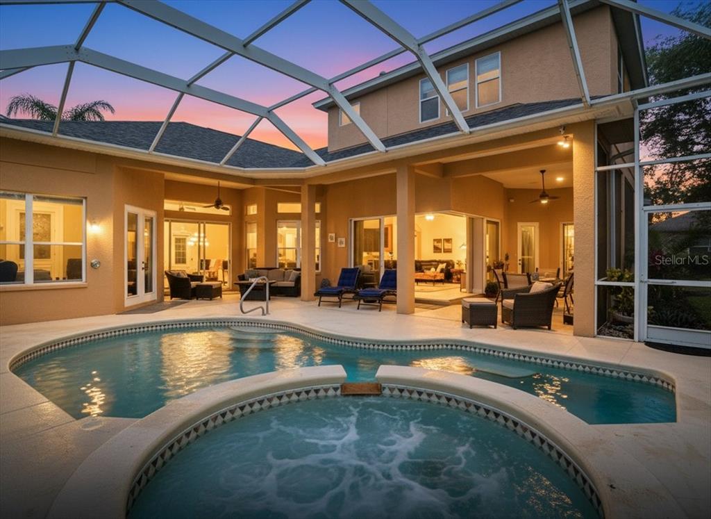 A screened-in patio features a swimming pool, a hot tub, and outdoor seating areas — 8843 17TH AVENUE CIRCLE NW, BRADENTON, FL