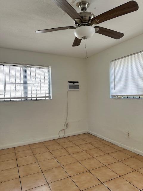 An empty room features beige tile flooring, a ceiling fan, and two windows with blinds — 807 Phippen Waiters Road # 2, Dania Beach FL 33004, DANIA BEACH, FL