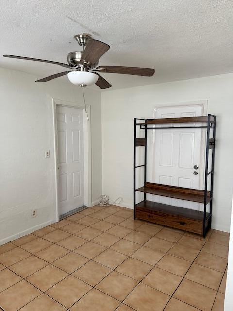 A room with tiled floors, a ceiling fan, two white doors, and a metal shelving unit — 807 Phippen Waiters Road # 2, Dania Beach FL 33004, DANIA BEACH, FL