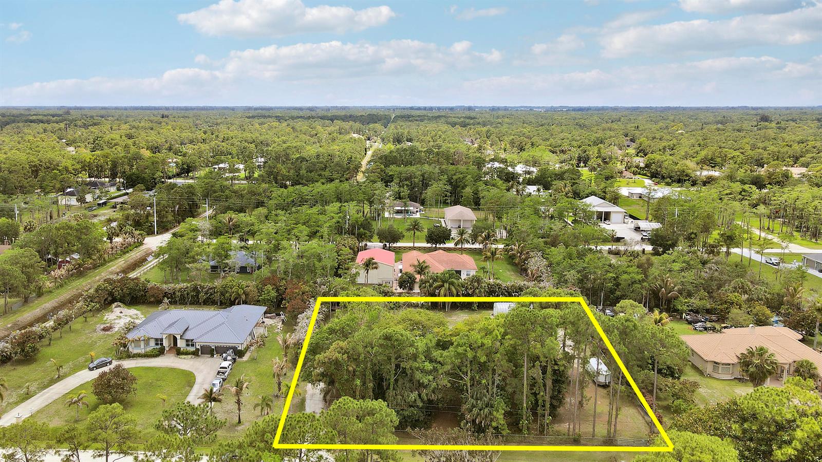An aerial view shows a wooded, rectangular lot outlined in yellow between two residential houses — 16296 81st Lane N, FL 33470, FL