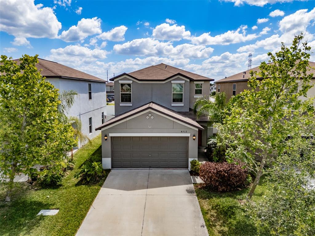 A two-story suburban house features a gray exterior, a two-car garage, and a concrete driveway — 4712 RON EDDIE, TAMPA, FL