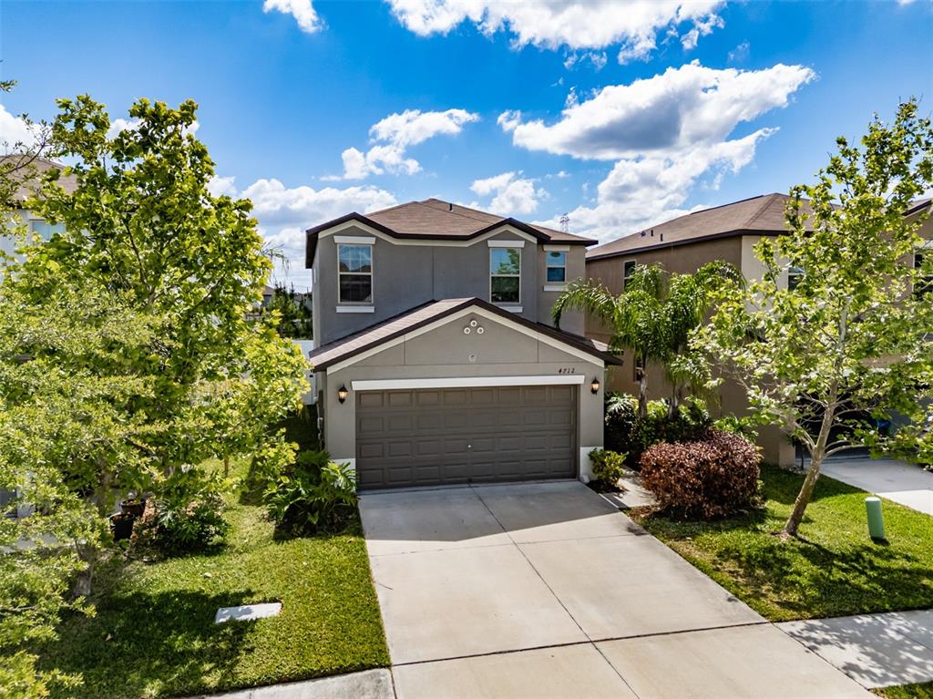 A two-story house with a gray exterior, a two-car garage, and a concrete driveway — 4712 RON EDDIE, TAMPA, FL
