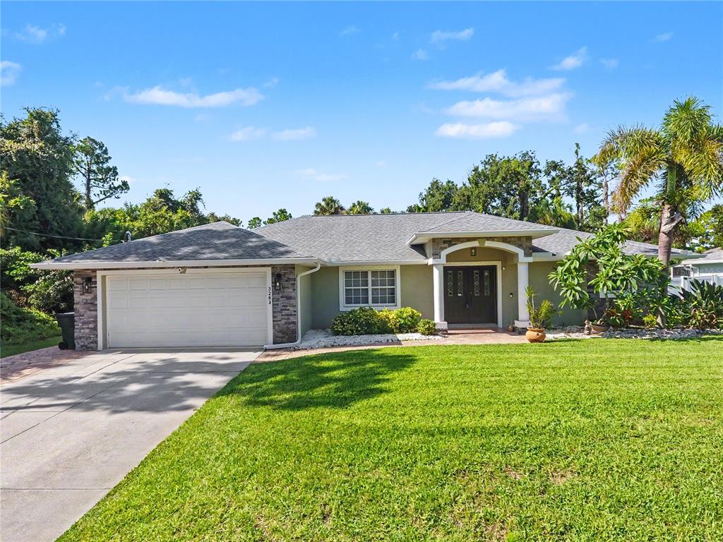 A single-story house with a stone-accented garage, a covered entryway, and a green lawn — 3283 SIKESTON AVENUE, NORTH PORT, FL