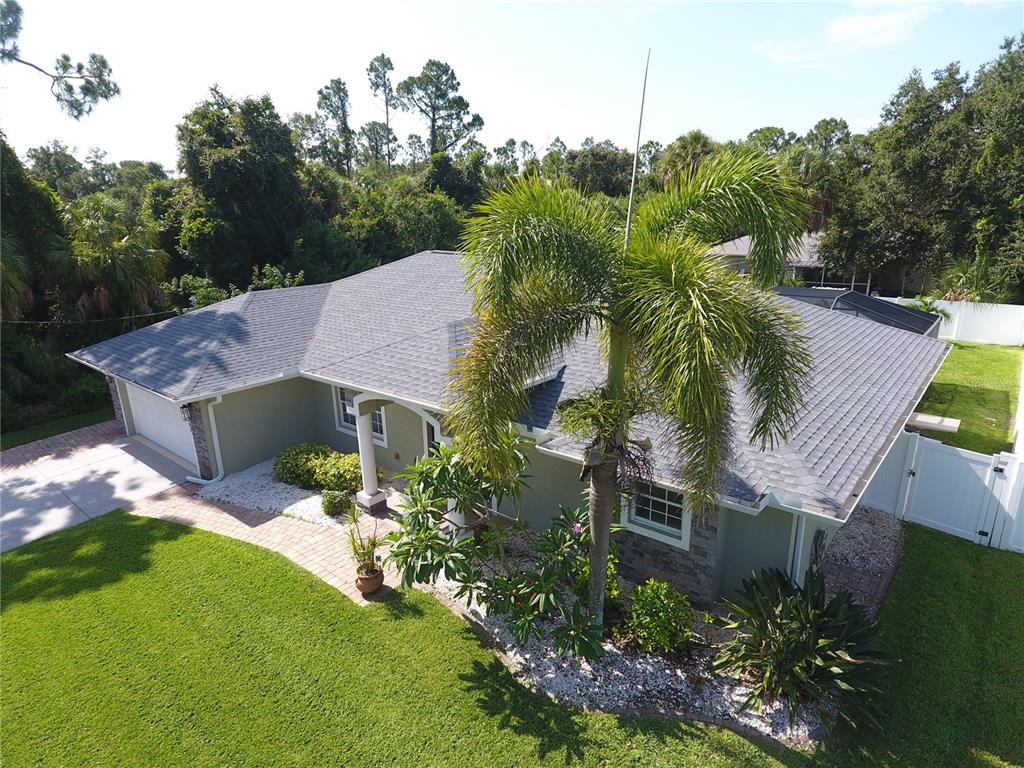 An aerial view of a single-story house with a gray roof and a palm tree — 3283 SIKESTON AVENUE, NORTH PORT, FL