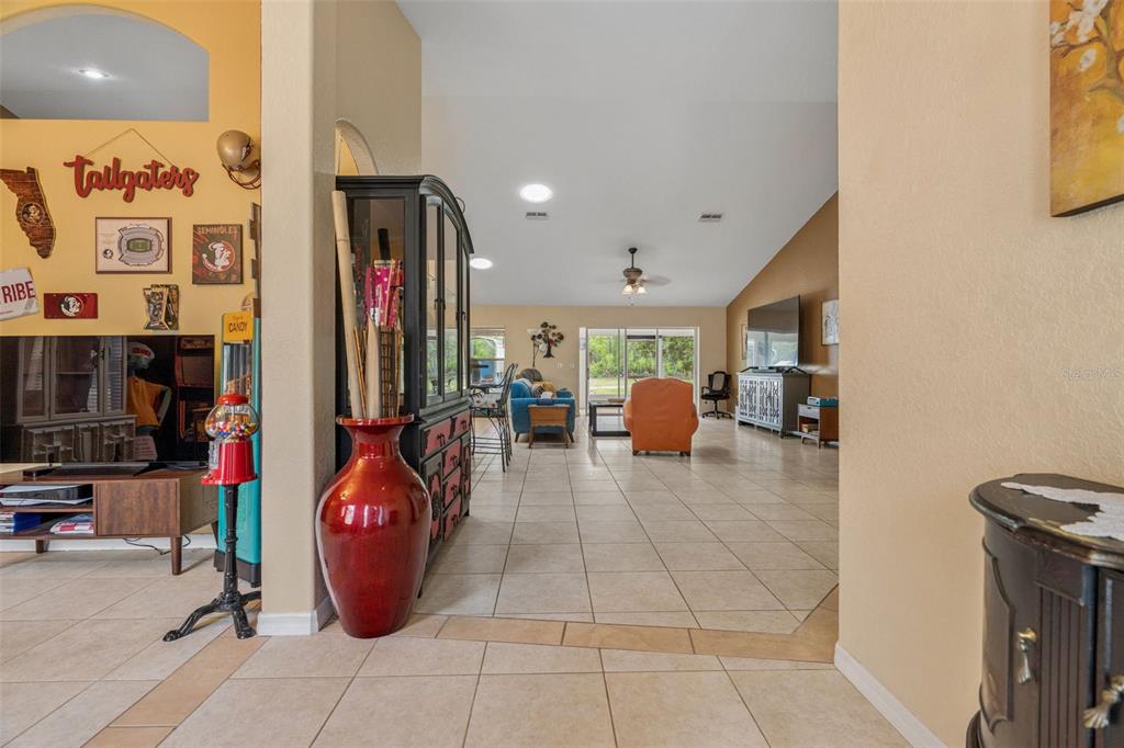 A tiled entryway leads into an open-concept living area with a vaulted ceiling and patio — 4350 W HORSESHOE DRIVE, BEVERLY HILLS, FL