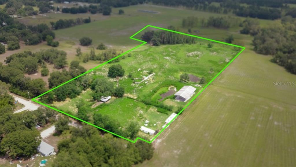 An aerial view shows a large, grassy lot outlined in green with two small structures — 8206 BACK ROAD, PLANT CITY, FL
