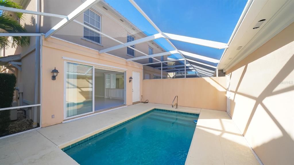 A rectangular swimming pool sits on a patio enclosed by a screened-in lanai — 5373 DAVINI STREET, SARASOTA, FL